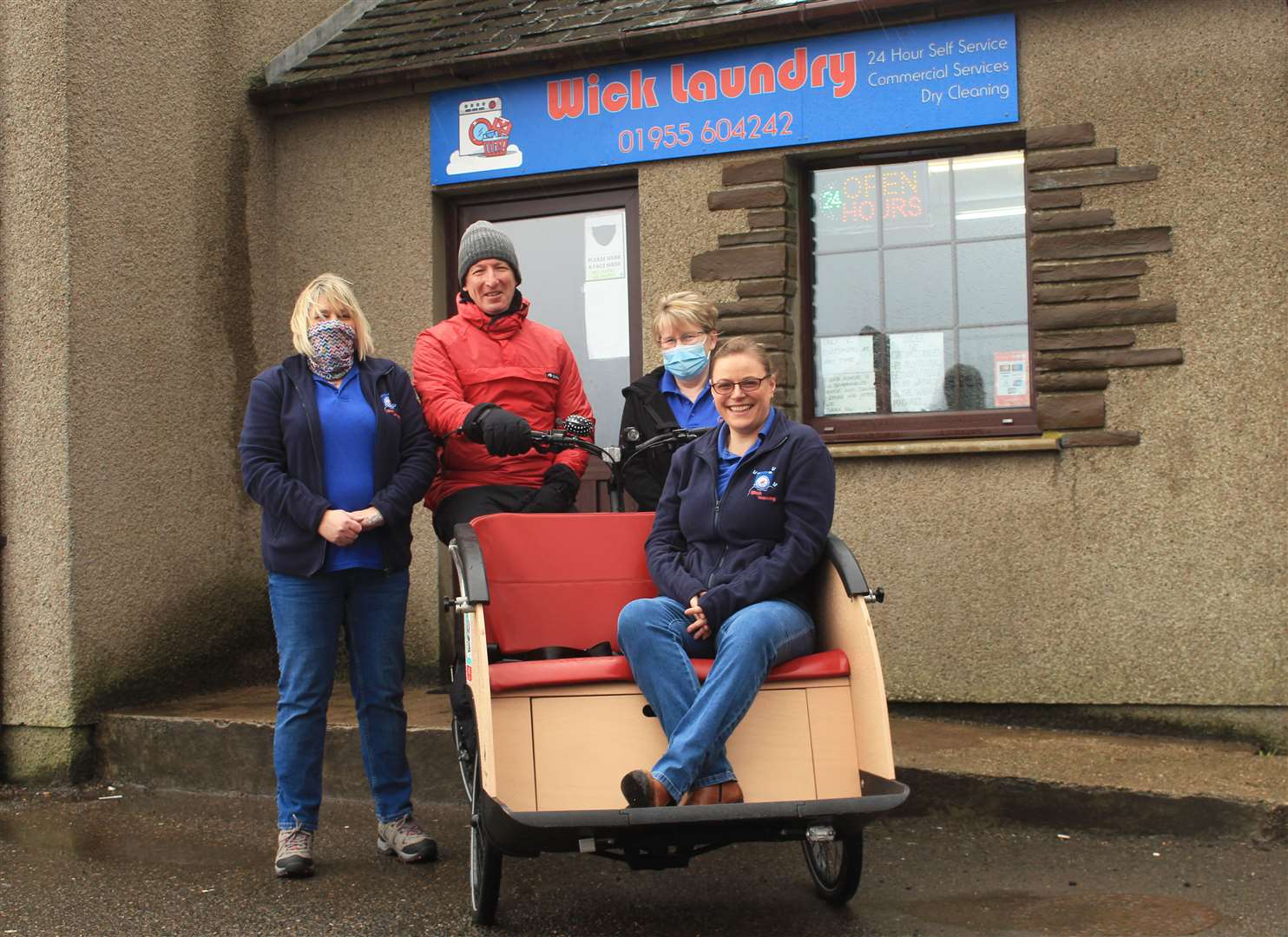 George Ewing, of the Wick chapter of Cycling Without Age, with Wick Laundry manager Caitlin Mowat sitting in the trishaw and laundry staff Tracy Bain (left) and Lianna Bain looking on.