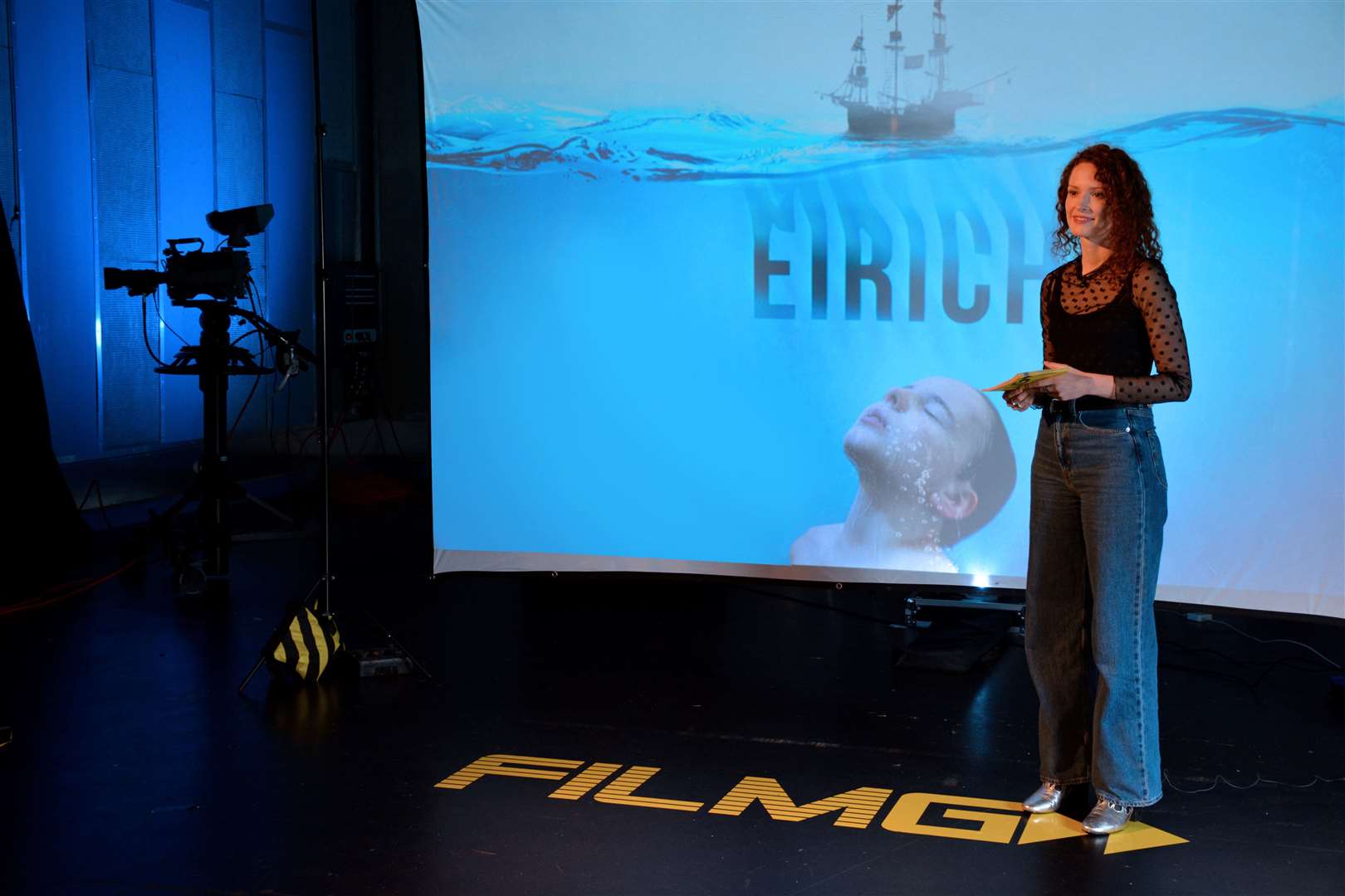 BBC Alba presenter Shona Masson unveiling FilmG's theme artwork for this year.