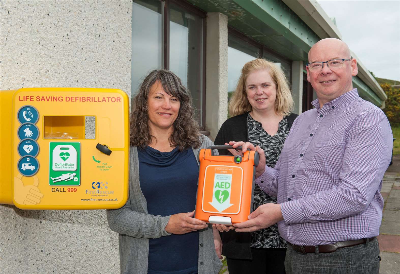 At Strathy village hall with the defibrillator (from left) school nurse Janelle Spratt; Carol-Anne Farquhar, Strathy hall committee chairperson; and SSE Renewables community fund manager David Shearer. Picture: Mike Roper