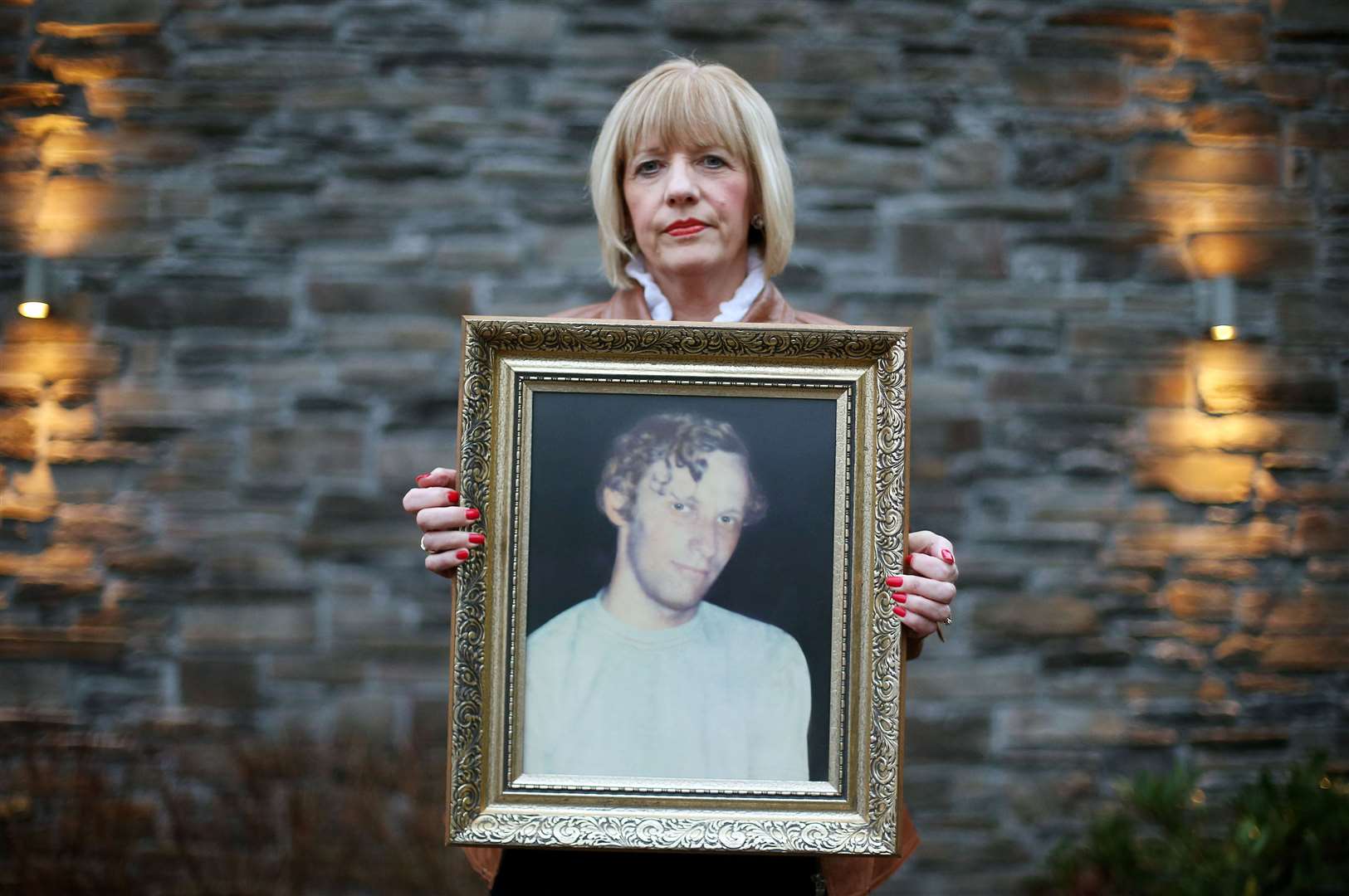 Karen Armstrong holds a photograph of her brother John McConville (Brian Lawless/PA)