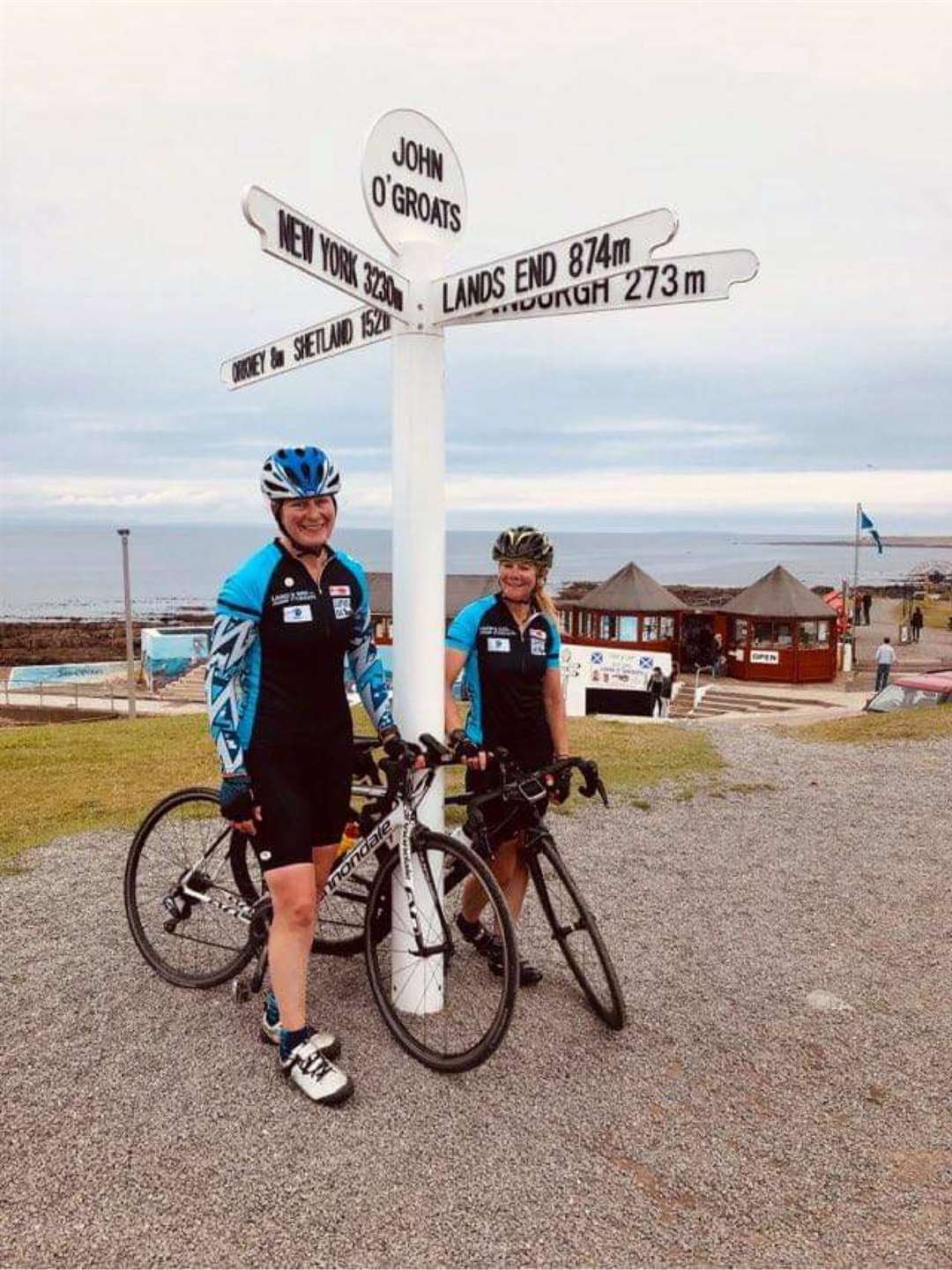 Maddy and Jo delighted to reach John O'Groats as they complete the Wheelie Wheelie Big Ride.
