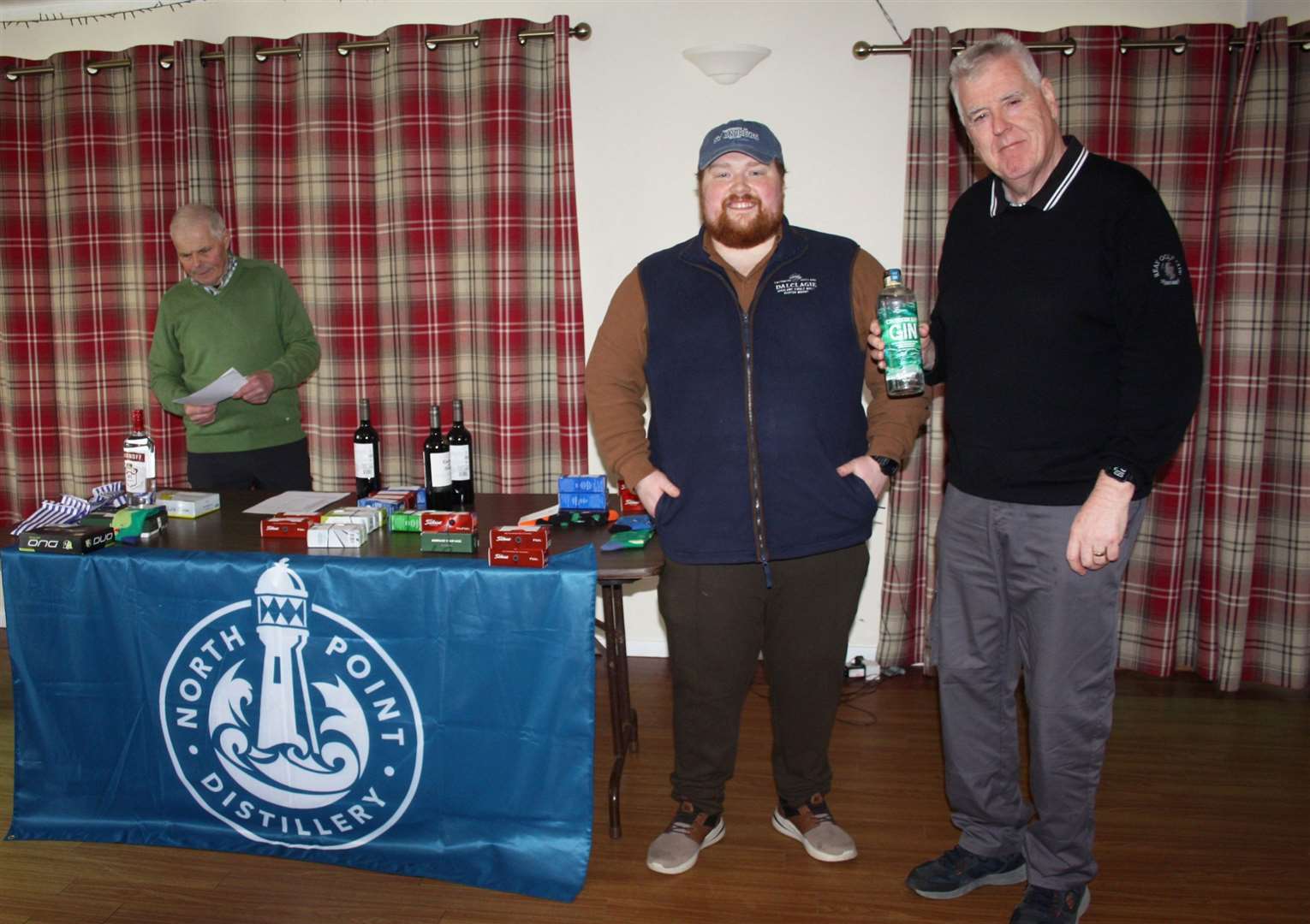 Alex Anderson (right) receives his prizes for winning the overall seniors’ winter eclectic and Stableford competitions from Alex MacDonald, co-founder of North Point Distillery, with seniors convener Sandy Chisholm in the background.