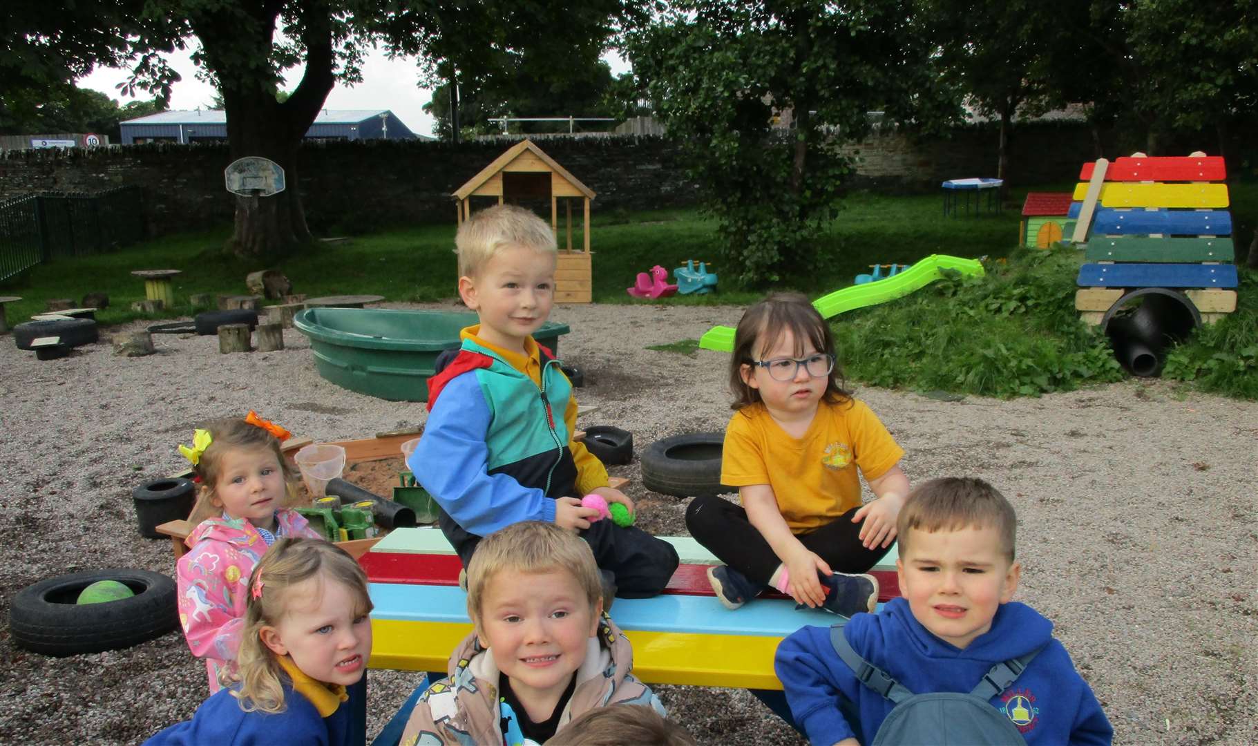 Some of the ELC learners who were so happy to get their new bench in their outdoor learning garden.