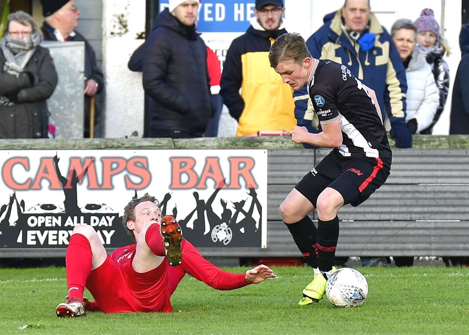 Brora's Ally Macdonald is left on the ground as he is turned by Wick Academy's Mark Macadie. Picture: Mel Roger