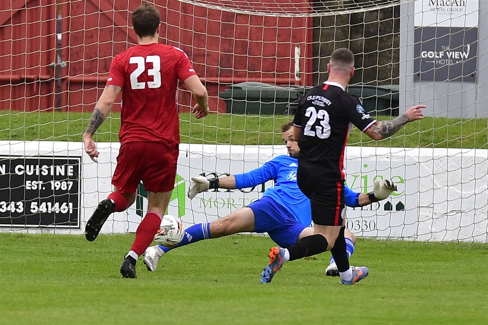 Lossiemouth keeper Cameron Farquhar blocks a shot from Wick Academy's Gordon MacNab. Picture: Mel Roger