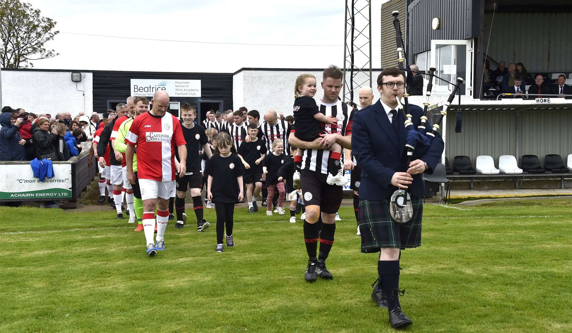 Piper Lewis Macleod leads out Alan Farquhar with daughter Ivy, followed by SPL Legends, Wick Academy players past and present, and mascots. Picture: Mel Roger