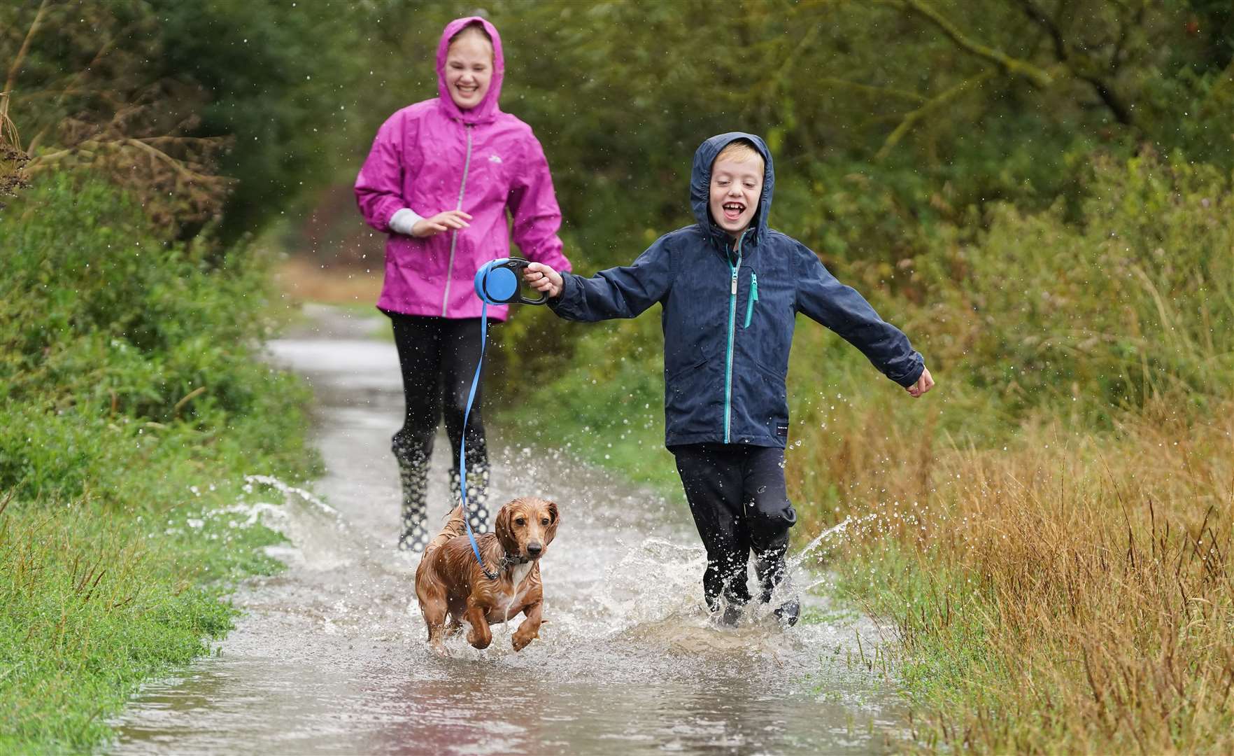 His owners Mia West, 11, and Jack West, 7, shared in the splashy fun in appropriately named Rainham in Kent (Ian West/PA)