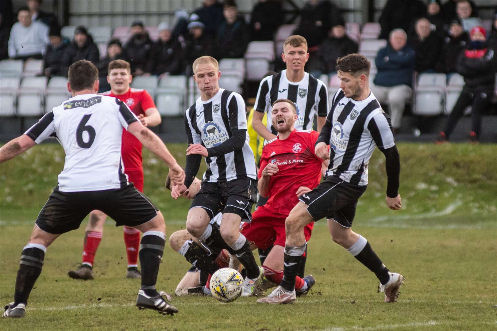 Lossiemouth's Ryan Stuart is outnumbered by Fraserburgh players at Grant Park. Picture: Daniel Forsyth