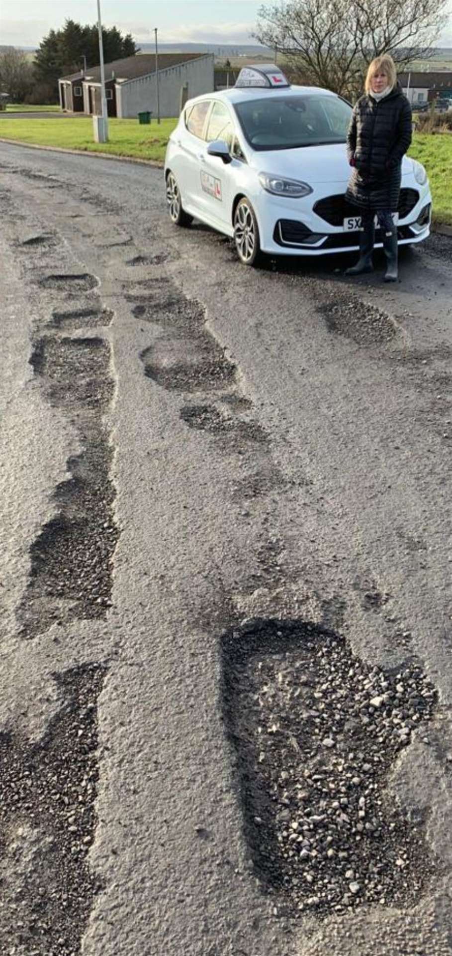 Debbie Aitkenhead with her car on the road leading to the test centre at Wick Airport Industrial Estate.