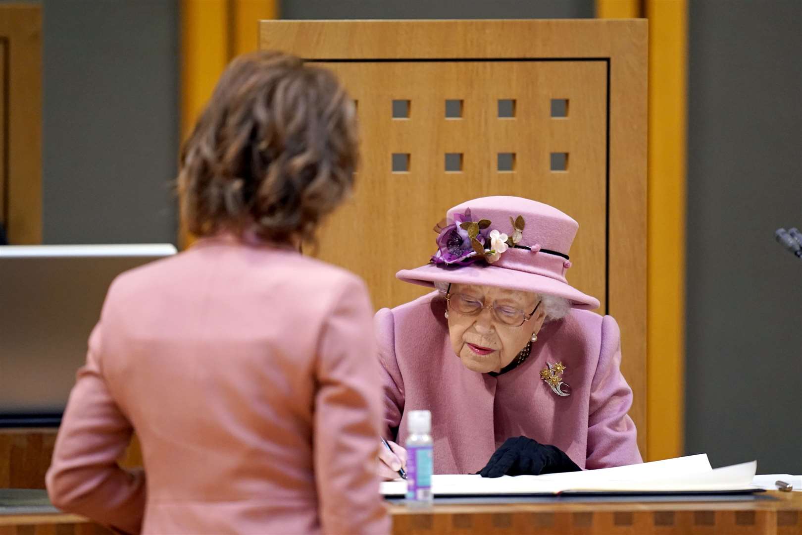 The Queen signs a commemorative parchment in the chamber (Andrew Matthews/PA)