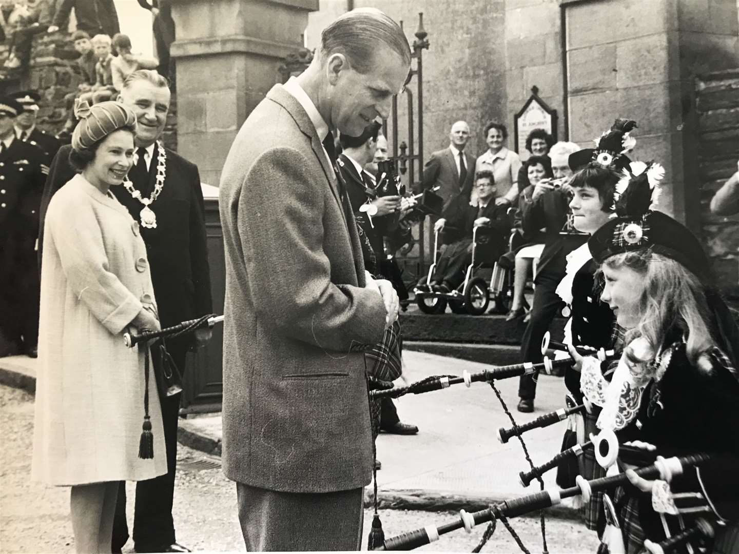 Prince Philip meeting some young pipers outside Wick Parish Church while the Queen looks on along with Provost William Dunnett. Picture courtesy of Miss Anne Dunnett.