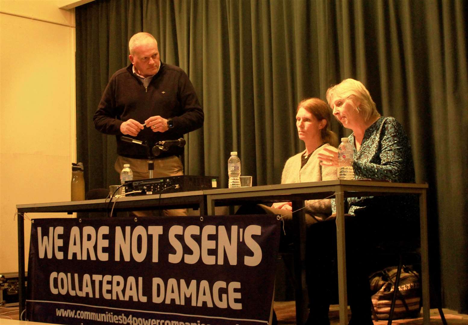Community council chairman Angus MacInnes looks on as Lyndsey Ward makes a point during this week's public meeting in Dunbeath, with her fellow CB4PC campaigner Denise Davis alongside.