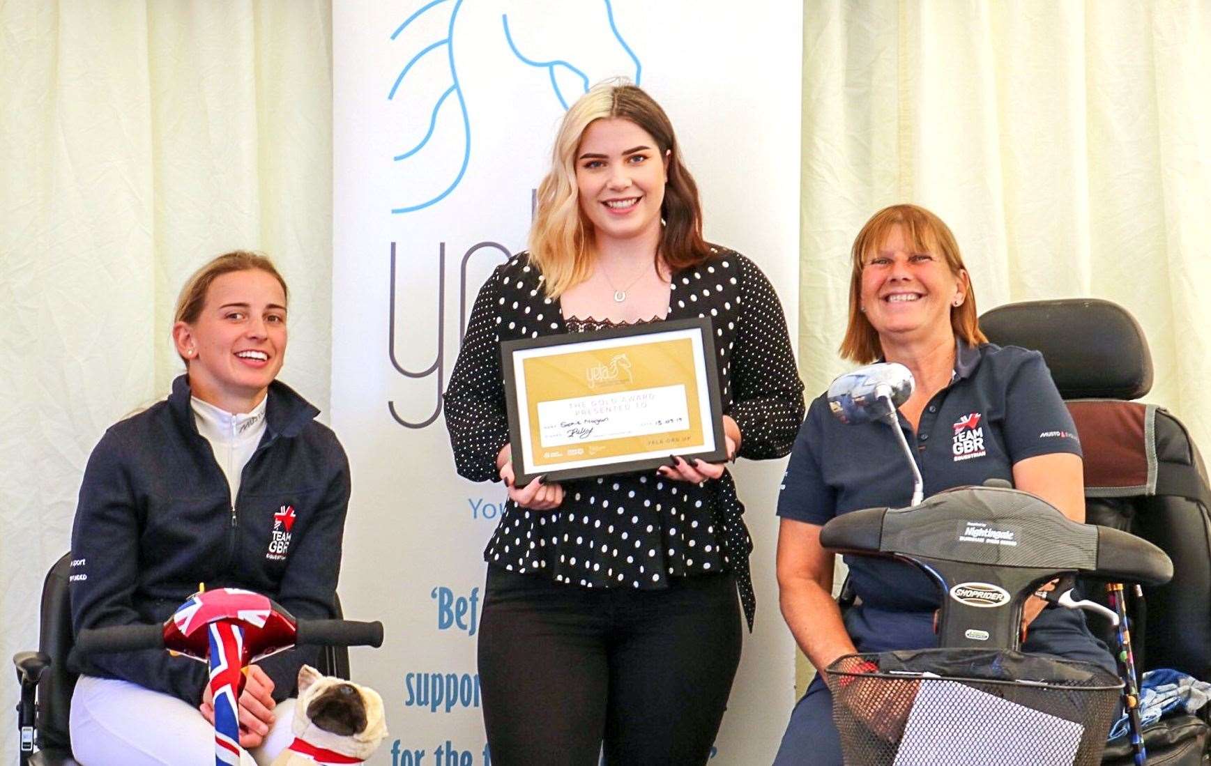Sophie Morgan receives her YELA gold award from Equestrian Team GBR para riders Georgia Wilson (left) and Julie Payne.
