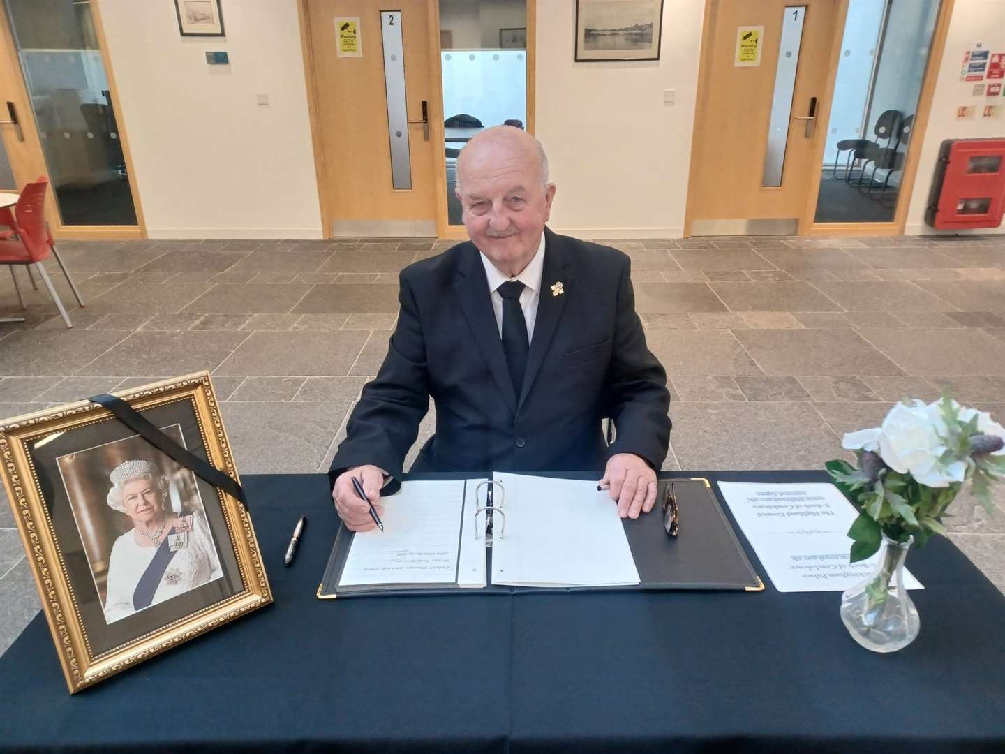 Councillor Willie Mackay signing the book of condolence at Caithness House.