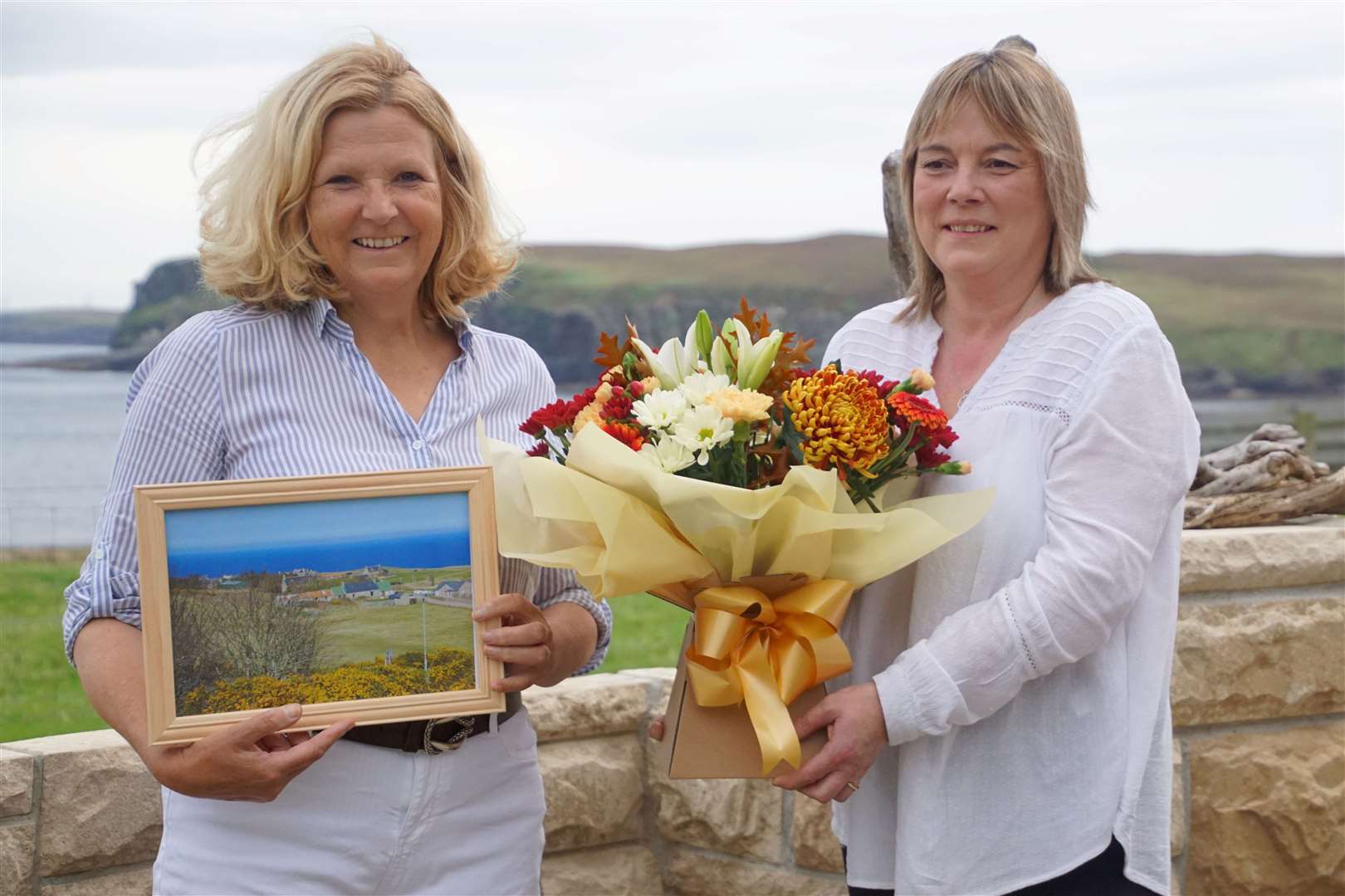 Rosemary Cameron (right) who worked in the shop receives a bouquet of flowers and a picture from Debbie Murray of Strath Halladale.