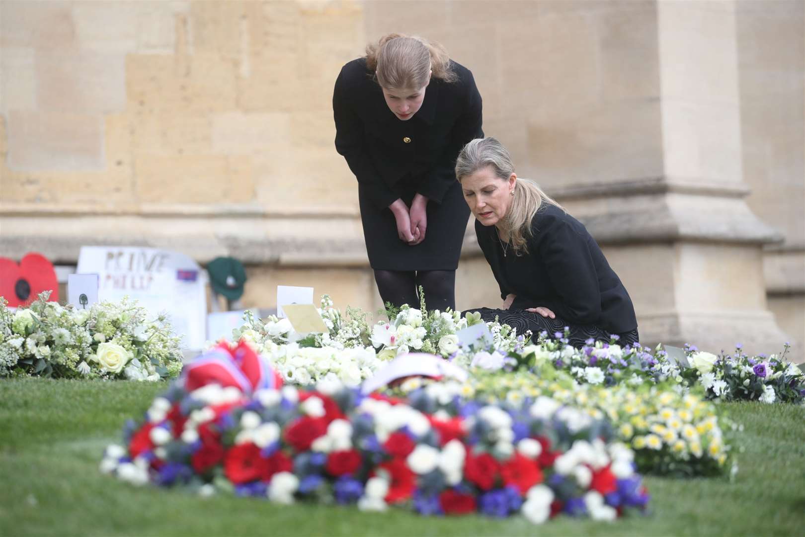The Countess of Wessex and Lady Louise Windsor view flowers outside St George’s Chapel (Steve Parsons/PA)