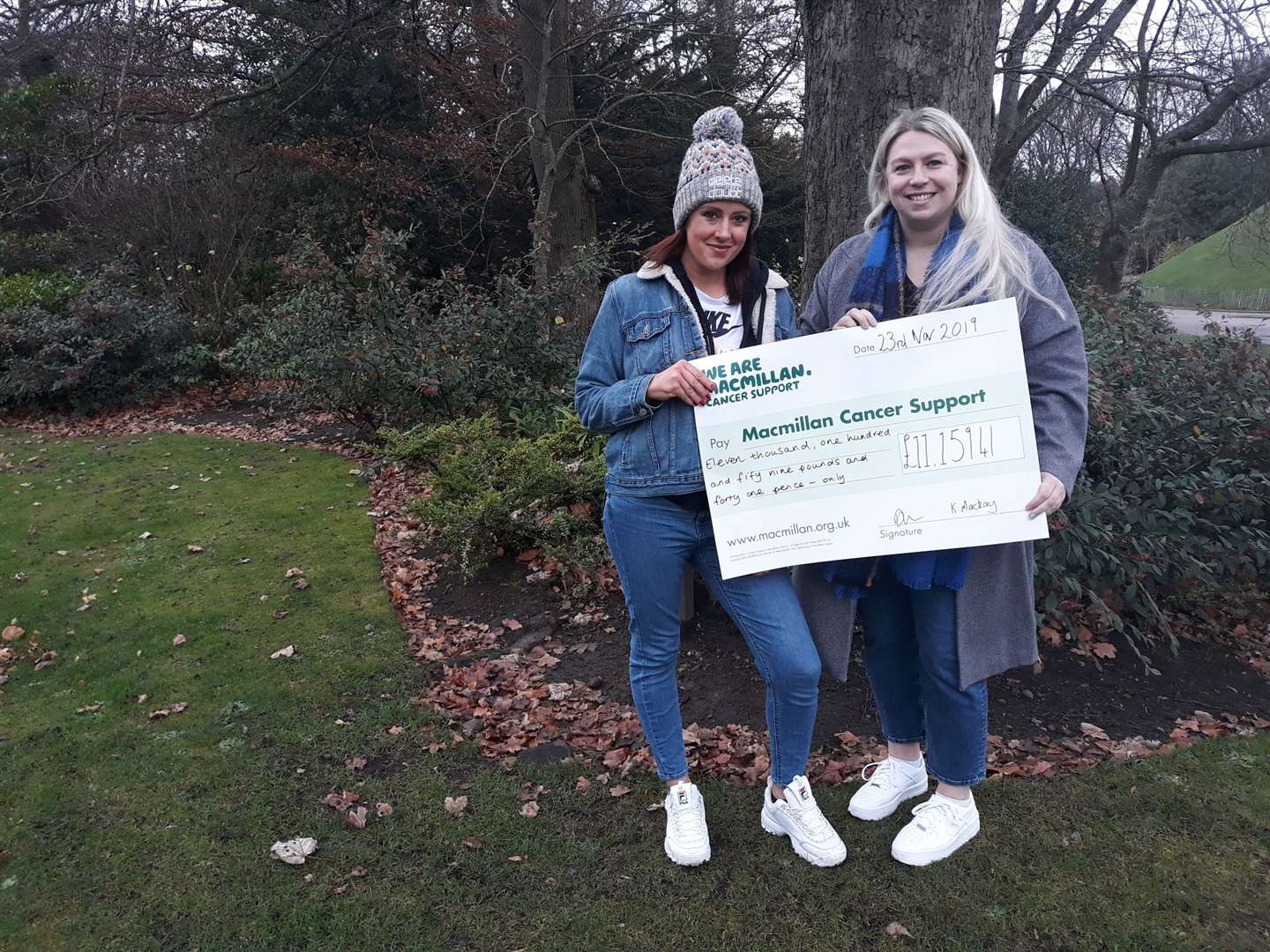 Kelly (left) and Donna with their bumper cheque for Macmillan Cancer Support after they completed their bespoke 26-mile route from Thurso to Loch More.