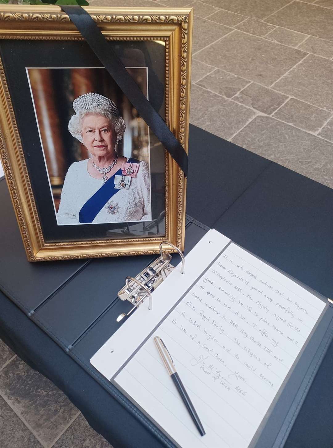 Provost McEwan's message in the book of condolence at Caithness House, alongside a portrait of the late Queen.