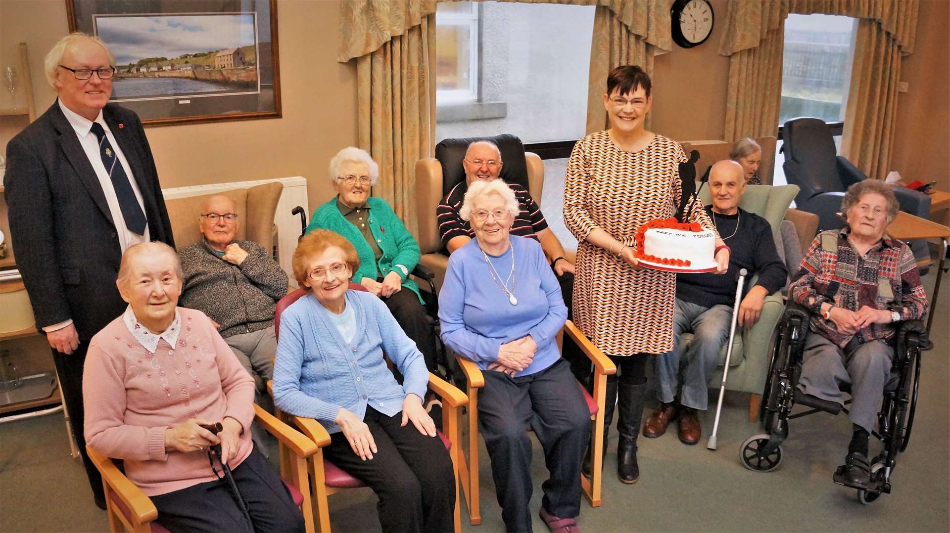 Anne Campbell holds her special Remembrance themed cake which was donated to the residents of Pulteney House who are pictured along with Murray Lamont from Mackays Hotel. Pictures: DGS