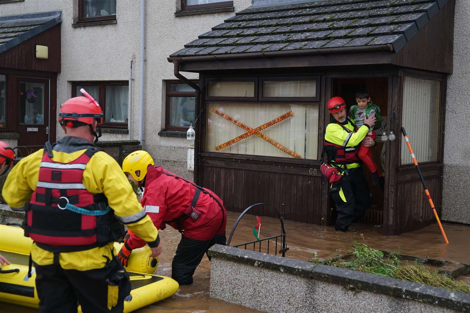 A boy was carried from a house in Brechin, Angus, as Storm Babet batters the country. (Andrew Milligan/PA)