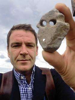 Ashley Cowie holds the stele found at the claimed burial site of wizard Murdo Rivach.