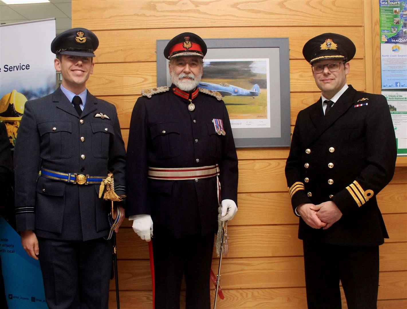 From left: Flight Lieutenant Calum Falconer, of 6 Squadron at RAF Lossiemouth, Lord Thurso, Lord-Lieutenant of Caithness, and Commander Ian Walker, of Vulcan, the Royal Navy representative, beside the newly unveiled Spitfire AA810 limited-edition print in the airport terminal at Wick. Picture: Alan Hendry