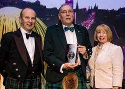 Rob Gibson pictured receiving his award at the Scottish Green Energy Awards flanked by compere Fred MacAulay and chief executive of Renewable UK Maria McCaffery.