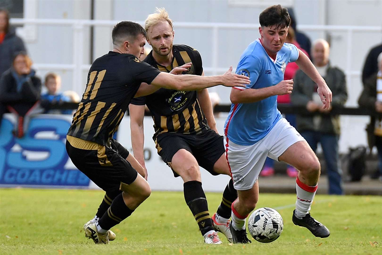Wick Academy's Kyle Henderson goes past Huntly duo Ross Still and Callum Murray. Picture: Mel Roger