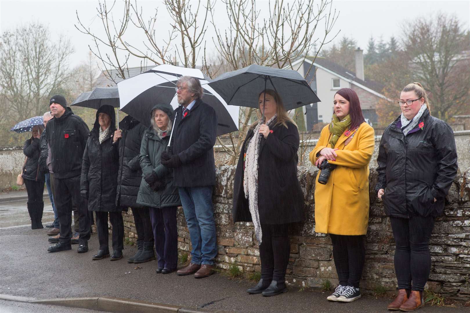 Sheltering from the rain during the remembrance service at Halkirk war memorial. Picture: Robert MacDonald / Northern Studios