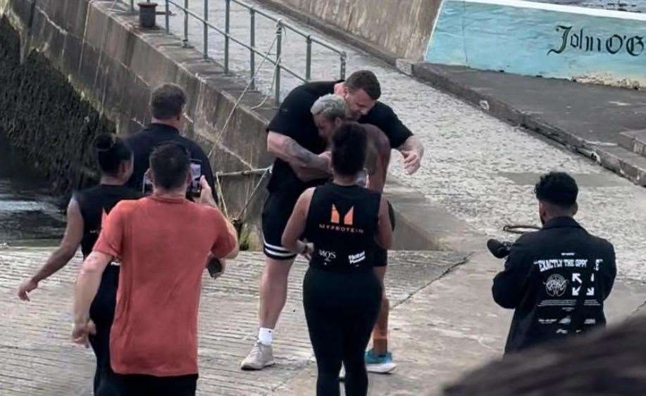 Ashley Cain was greeted by World's Strongest Man Tom Stoltman after completing the first leg of his challenge.