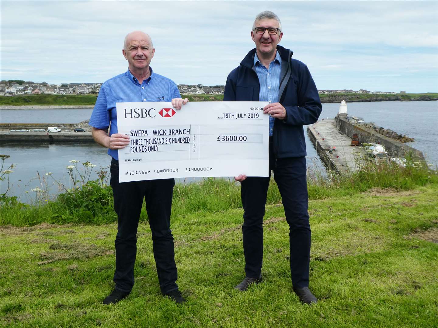 Andrew Bremner (left) handing over a cheque for £3600 on behalf of the Wick branch of the Scottish White Fish Producers Association to the Seafarers Memorial Group. It was accepted by Willie Watt.