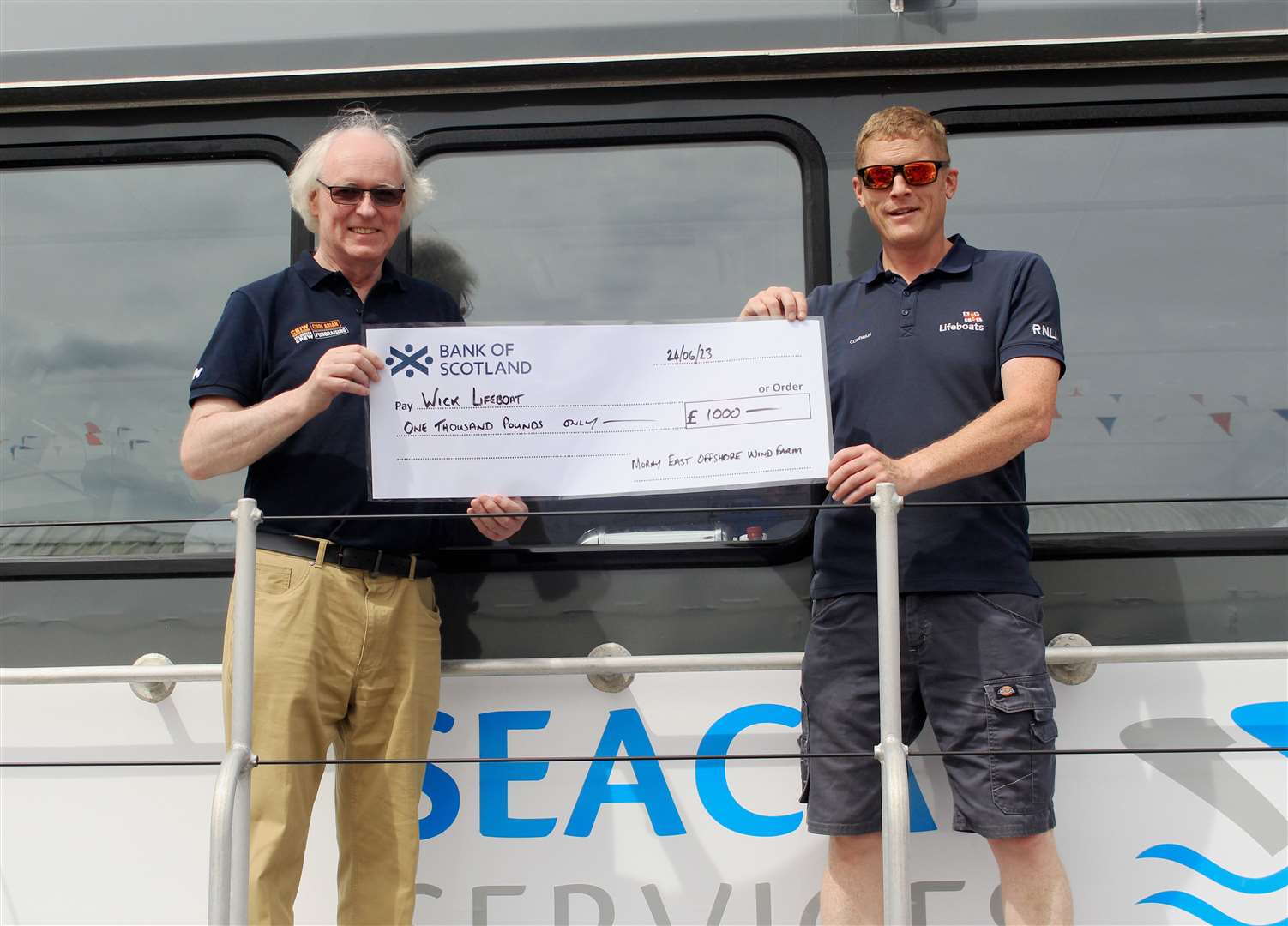 Murray Lamont, chairman of the Wick lifeboat management committee, and Allan Lipp, coxswain, with a £1000 cheque for Wick RNLI from Moray East offshore wind farm. Picture: Alan Hendry