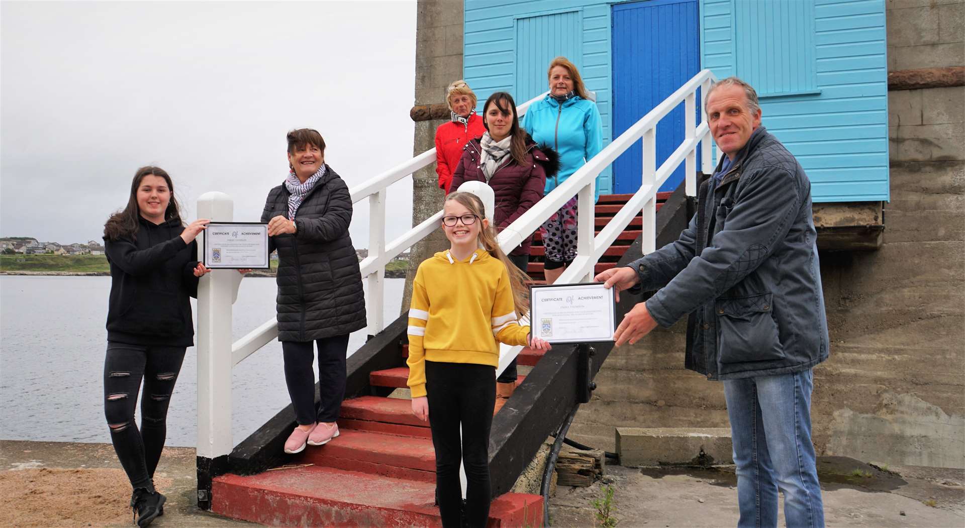 Sarah (left) receives her award from Doreen Turner, while Emma receives her one from Alastair Ferrier as other Wick community councillors look on. Picture: DGS