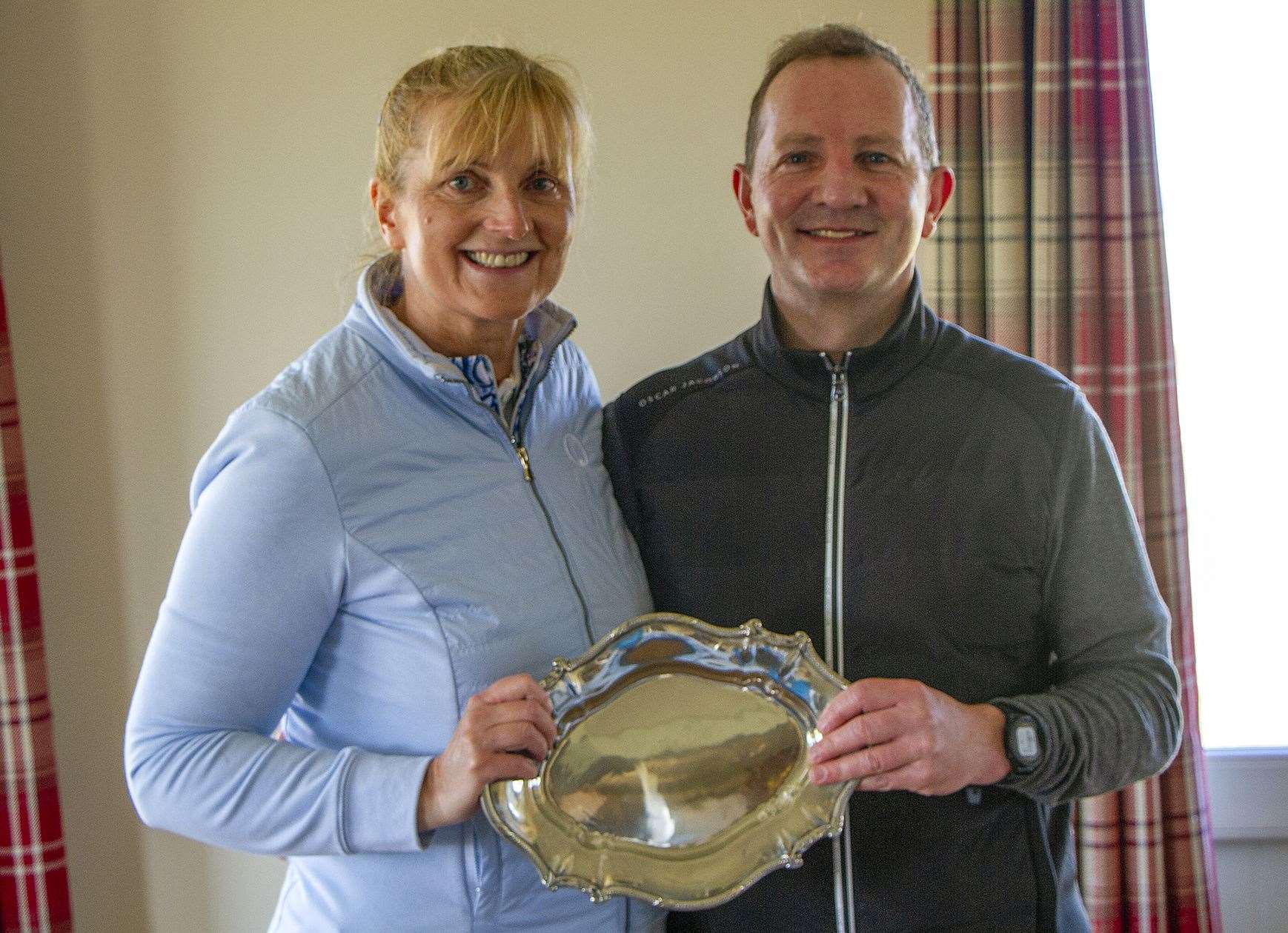 Vice-captain Carol Paterson receives the trophy from captain Andy Bain after her side won the Captain v Vice-Captain match by a score of 6.5 to 5.5.