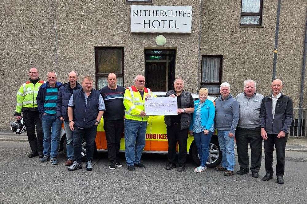 Mervyn Hill handing over the cheque for Highland and Islands Blood Bikes to David Mackay outside the Nethercliffe Hotel.
