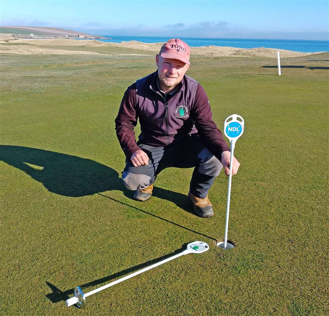Reay greenkeeper Jason Norwood showing off new pins the club received for the practice putting green thanks to sponsorship from NDL (Nuclear Decommissioning Ltd).