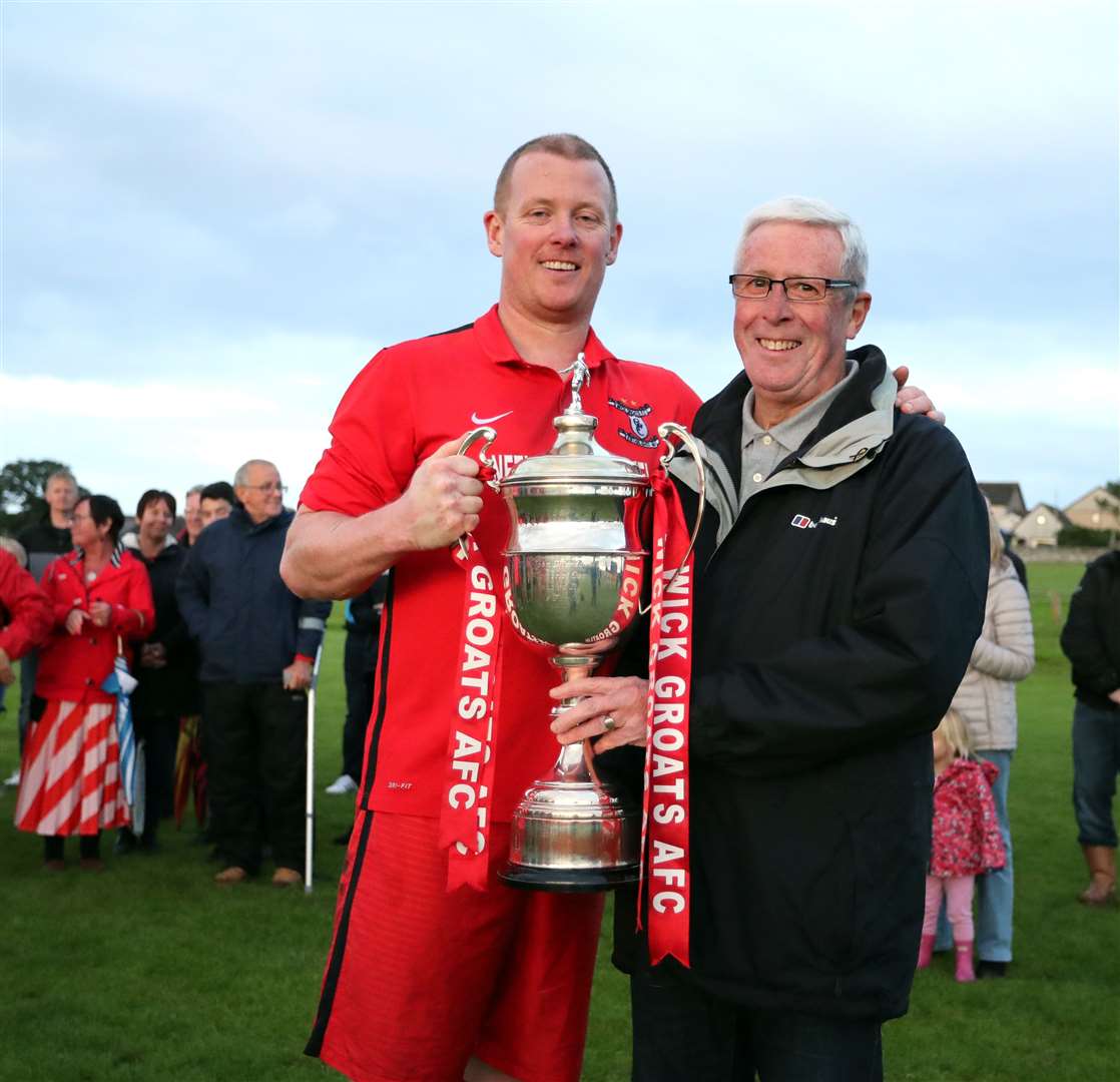 Wick Groats captain Alan Sinclair receives the Division One title from Murray Coghill, President of Caithness AFA. Picture: James Gunn