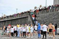 Participants in last year’s Dip with a Nip line up along Thurso beach as hundreds look on in support.