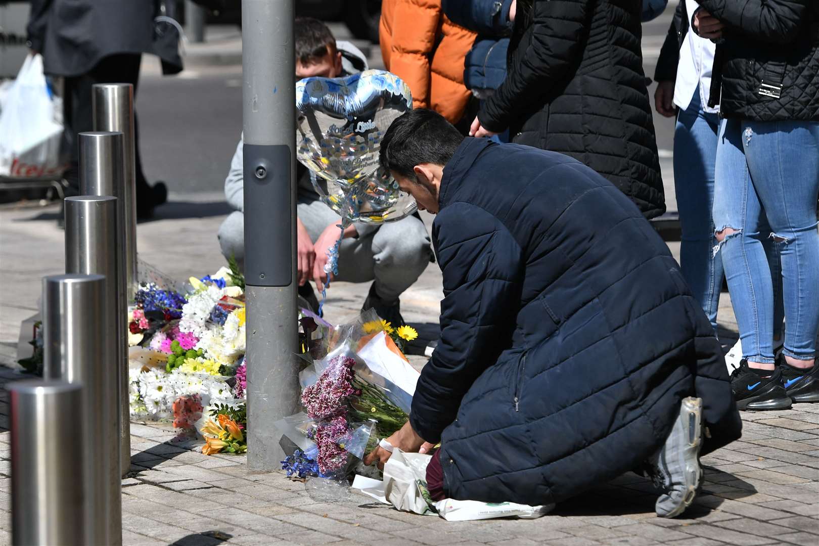 People place flowers at the scene in Barking Road, Newham, where 14-year-old Fares Maatou was knifed to death on Friday (Dominic Lipinski/PA)