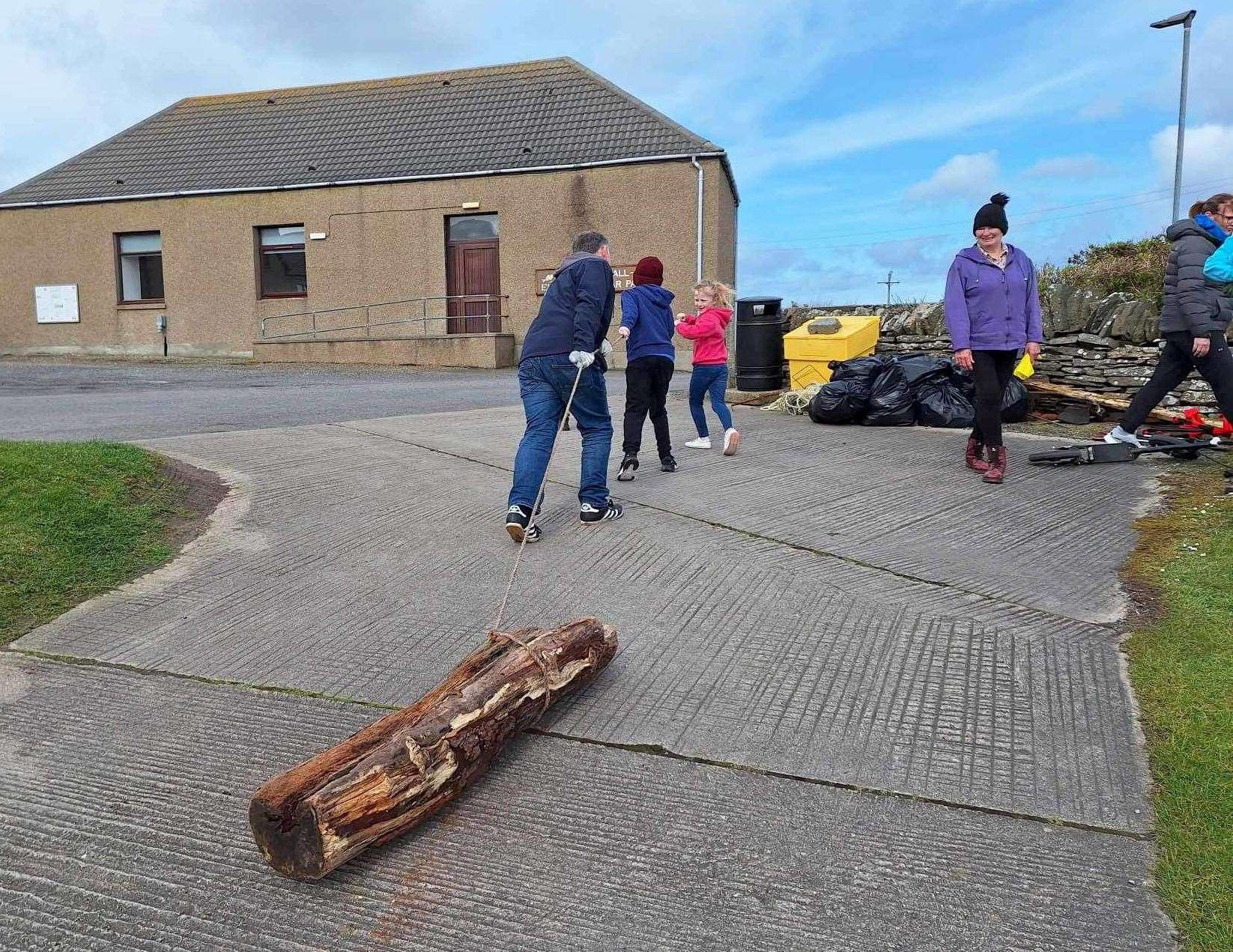 A team effort to haul a heavy log up from the harbour.