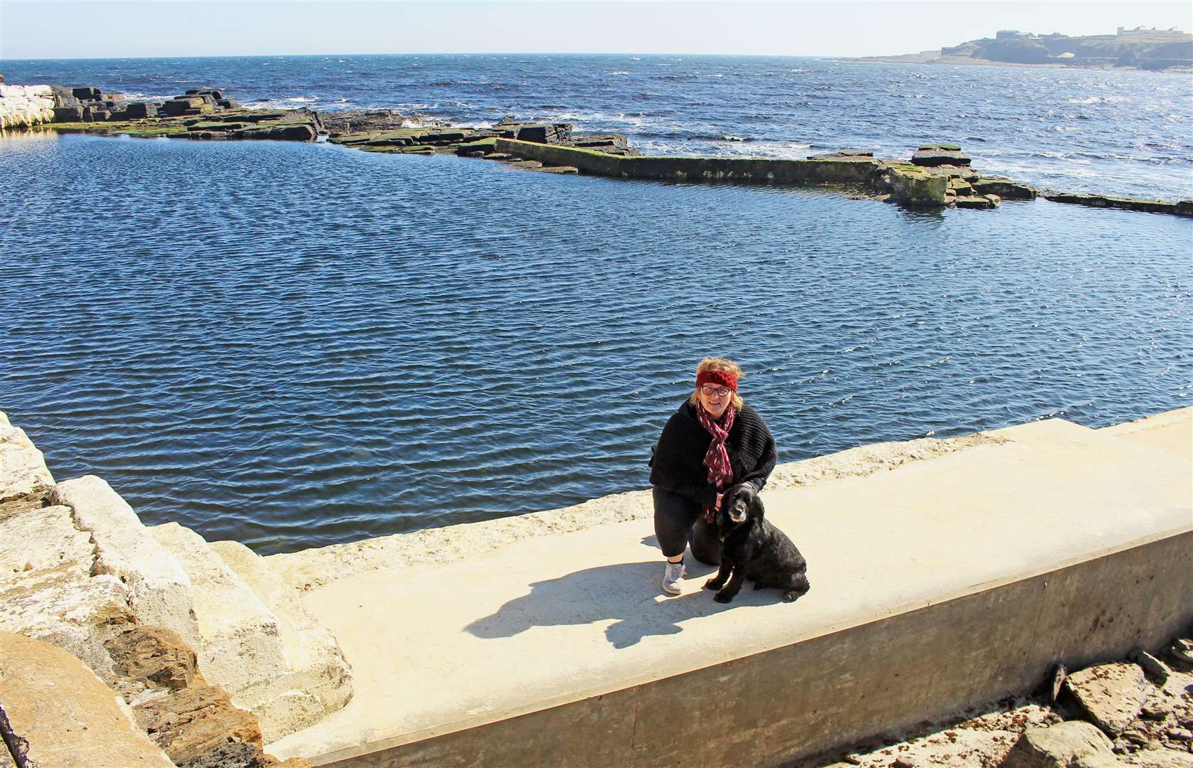 Patty Coghill, chairperson of Friends of the North Baths, with Alfie the dog on the repaired south-facing wall. Picture: Alan Hendry