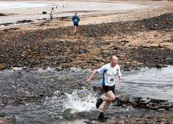 Kevin Cormack negotiates a water hazard at Dunnet beach on his way to being first home in North Highland Harriers’ first trail run of the new year. Picture: Robert MacDonald / Northern Studios.