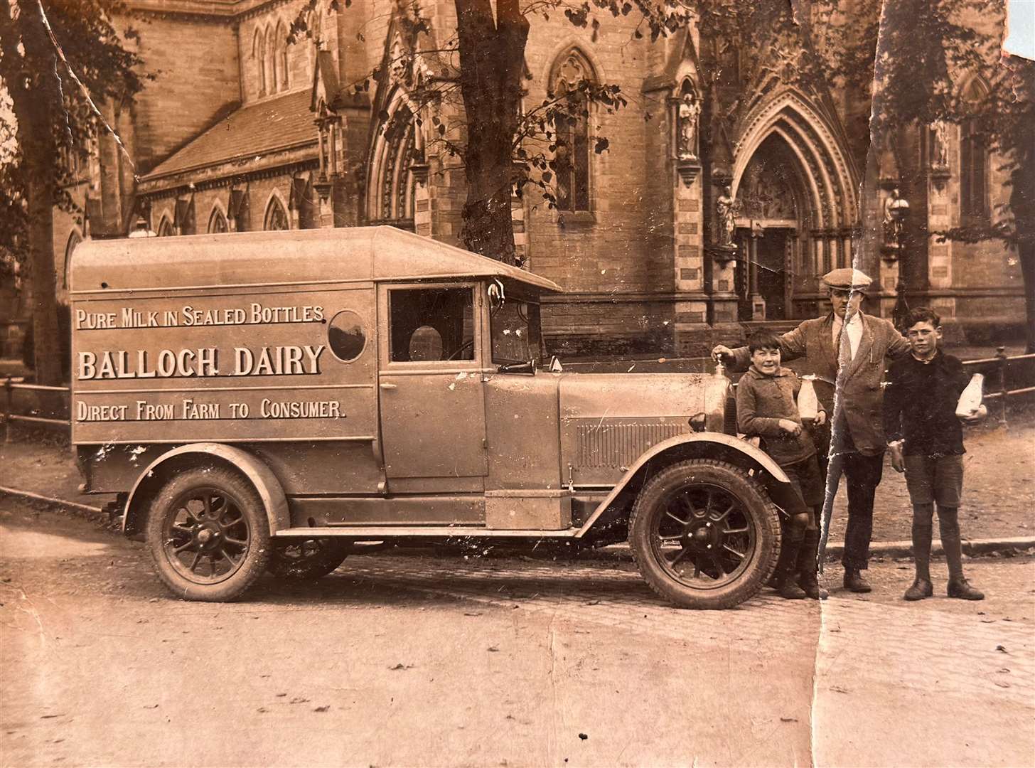 David Kennedy standing with two boys by the Balloch Dairy van outside of Inverness Cathedral.