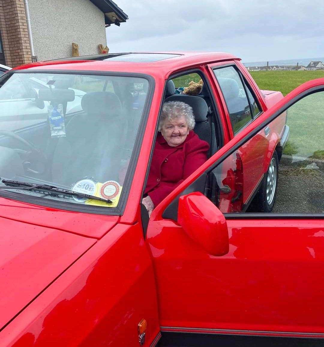 Resident Cathie Anderson sitting in one of the cars.