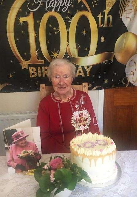 Dorrie Barnes on Sunday with her 100th birthday cake and her card from the Queen.