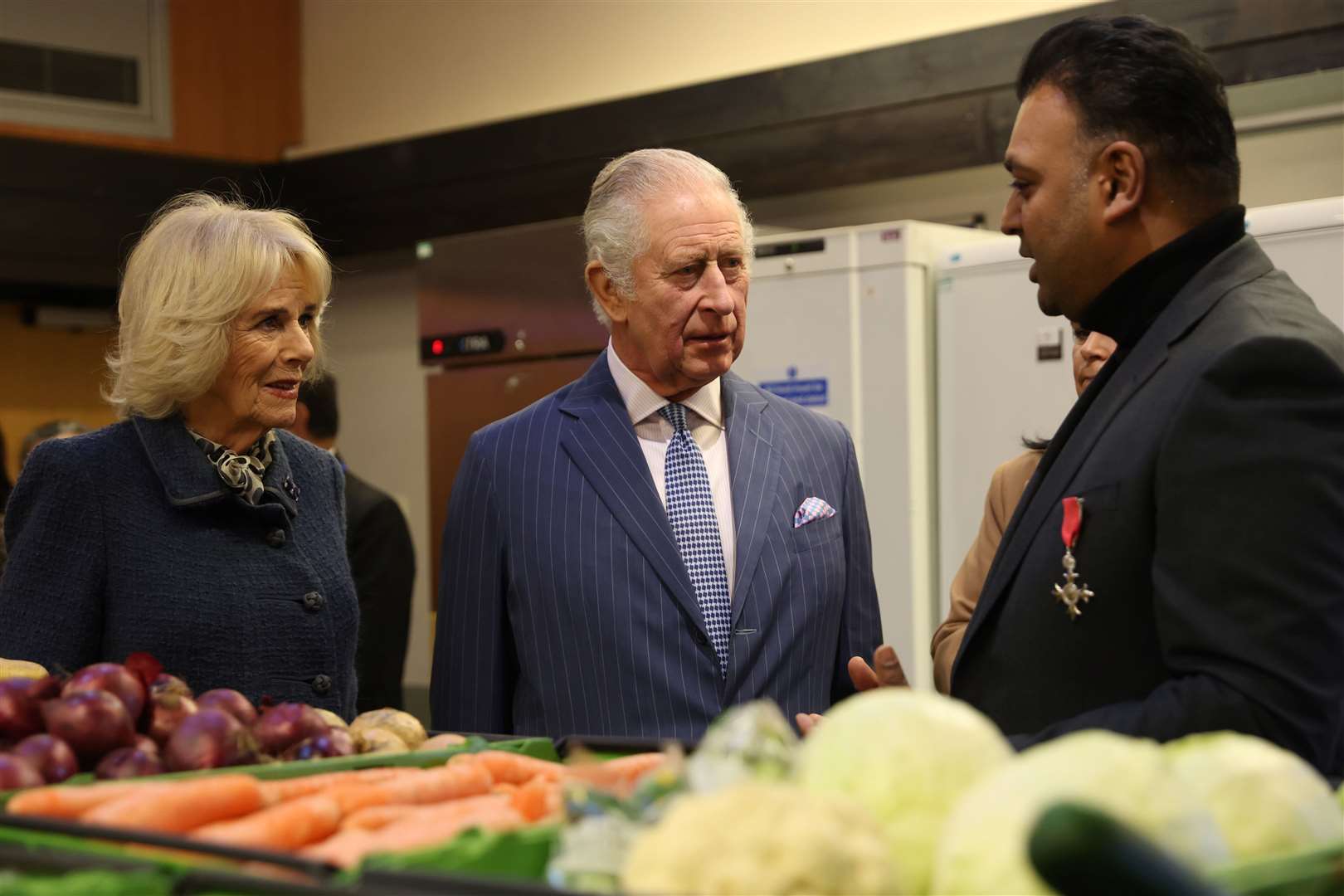 Charles and Camilla speak with chief executive and founder of London’s Community Kitchen Taz Khan (Isabel Infantes/PA)