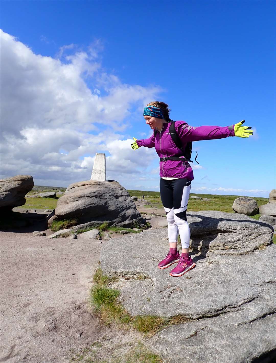 Meg rests against the wind at the summit of Kinder Low, the high point of the run.