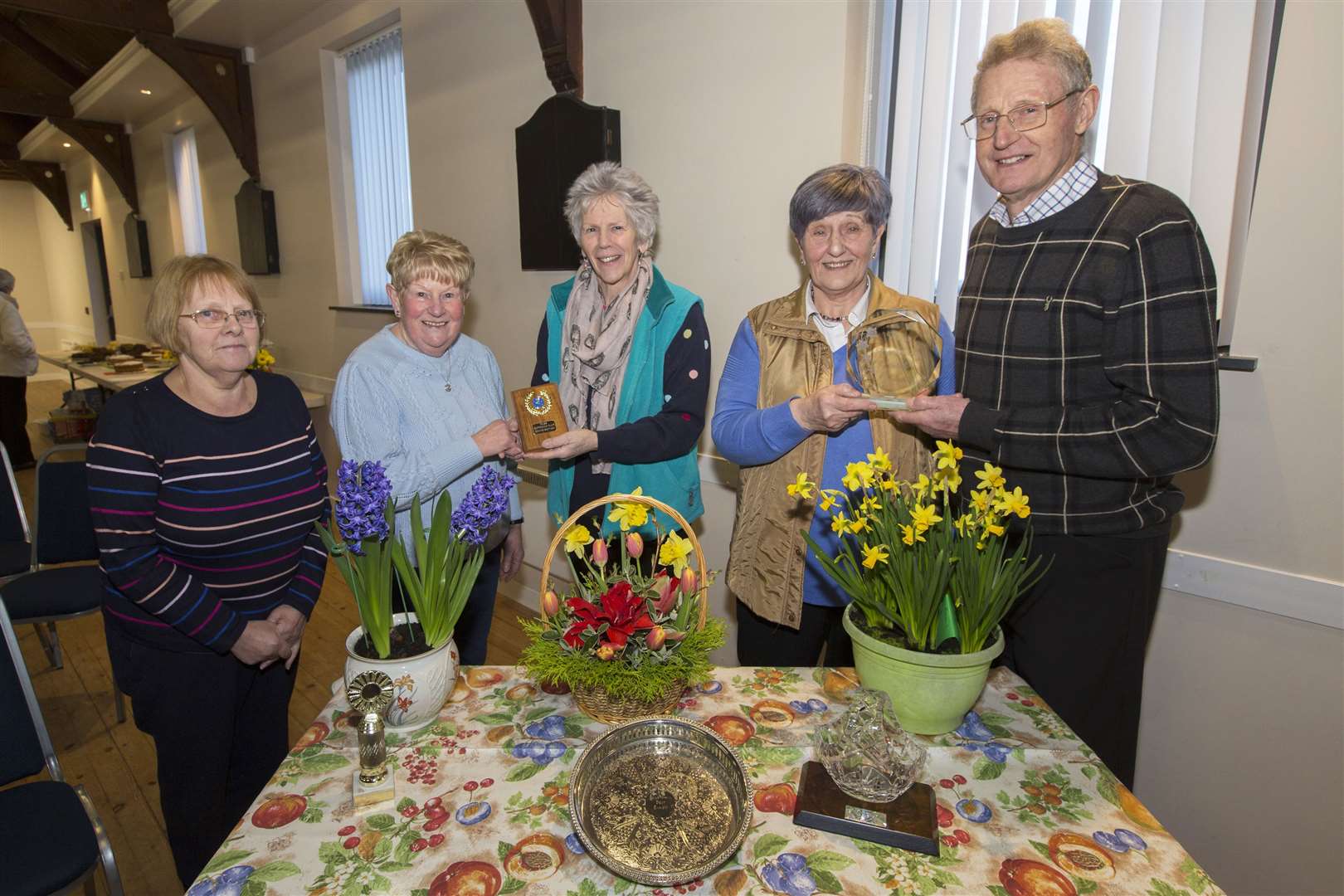 Marion Sutherland won the trophy for most points overall at Reiss Gardening Club's annual bulb show. She also won the trophies for bulbs and floral art. She is pictured receiving one of her trophies from show judge Bill Watson, while his wife and fellow judge Elaine (centre) presents the trophy for baking and preserves to Annette Sinclair. Looking on is Maureen Johnson who won the trophy for best exhibit with her amaryllis. Picture: Robert MacDonald / Northern Studios