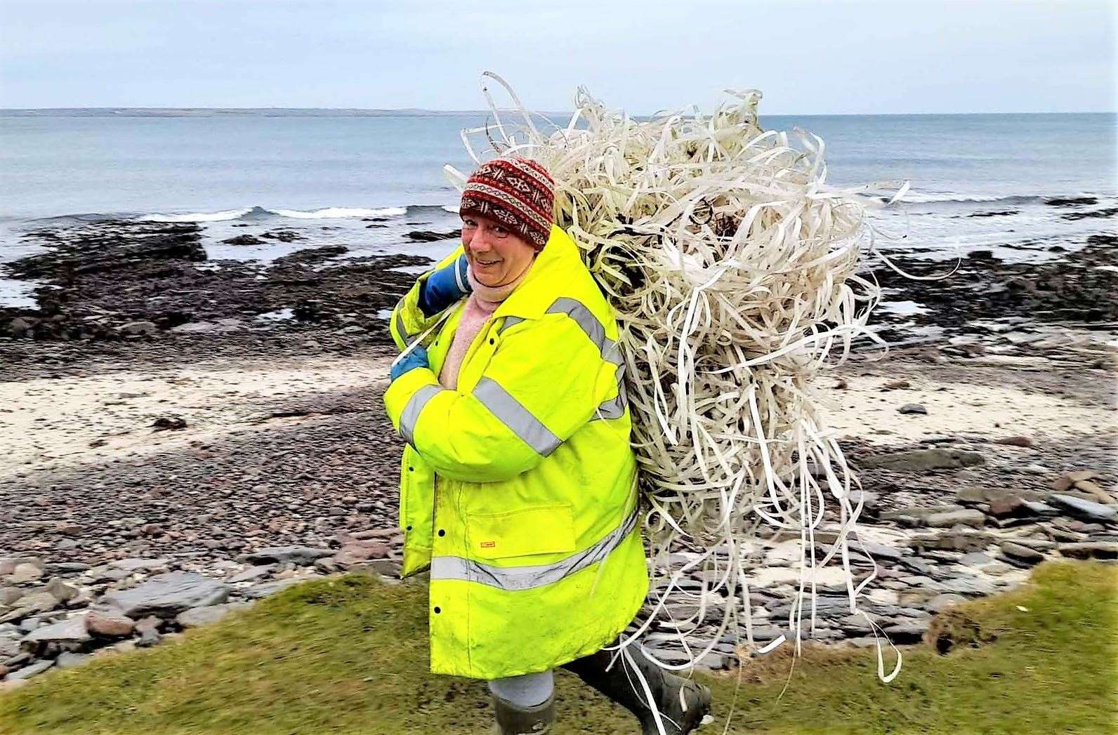 Caithness Beach Cleans stalwart Dorcas Sinclair removes one of the bundles. Pictures: Allan Sinclair
