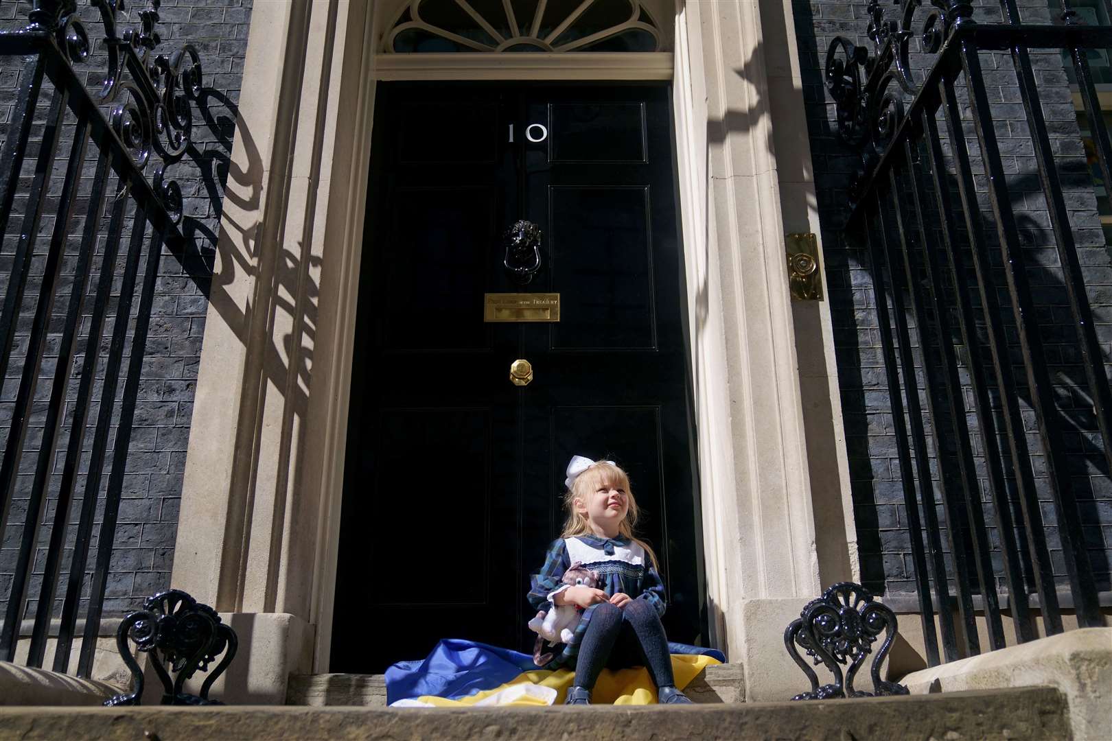 Ukrainian refugee Kira Ryndova, three, holds a Larry the cat soft toy on the steps of 10 Downing Street in May after visiting with her family to meet PM Boris Johnson. They arrived in the UK through the UK visa scheme, following Russia’s invasion in February (Victoria Jones/PA)